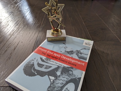 Photo of book: Front-End Web Development, The Big Nerd Ranch Guide. On top of book, small gold trophy with label that reads 'You wrote a book'